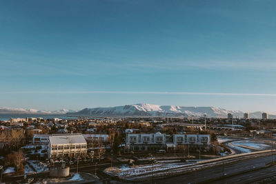 High angle view of city against blue sky