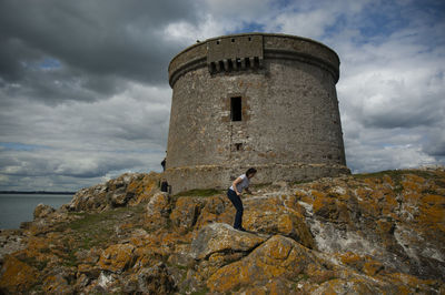 Full length of woman standing by built structure against sky