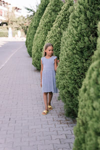 Candid happy little kid girl of eight years old full body height with long blond hair and green