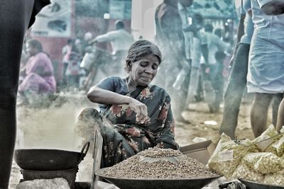 Full length of woman selling food for living at a busy marketplace