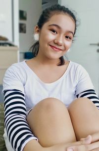 Portrait of a smiling girl sitting at home