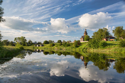 Scenic view of lake by buildings against sky