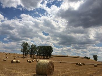 Hay bales on field against sky