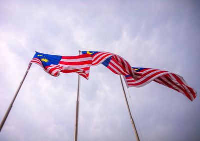Low angle view of flags flag against sky