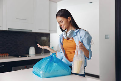 Portrait of smiling young woman standing at home