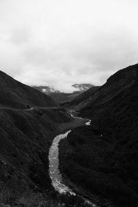 Scenic view of road leading towards mountains against sky