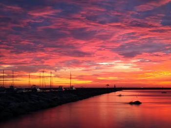 Scenic view of sea against dramatic sky during sunset