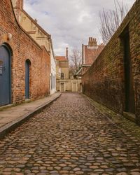 Cobblestone street amidst buildings in city