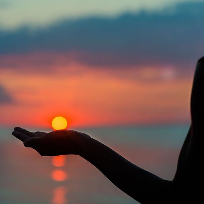 CLOSE-UP OF SILHOUETTE HAND HOLDING SUN