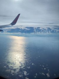 Airplane flying over sea against sky