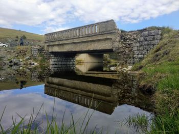 Built structure by lake against sky