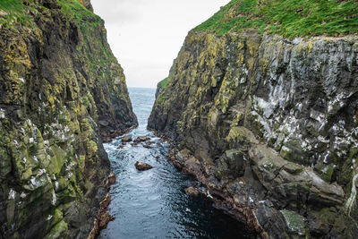 Rock formations in sea against sky