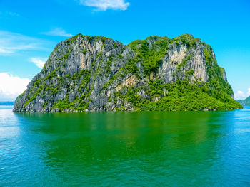 Scenic view of rocks in sea against blue sky