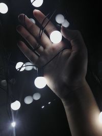 Close-up of hand holding illuminated lighting equipment