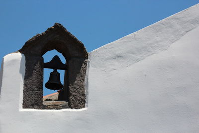 Low angle view of bell on chapel against sky