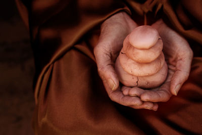 Cropped hands holding stacked pebbles