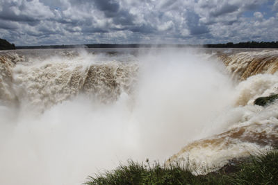 Scenic view of waterfall against sky