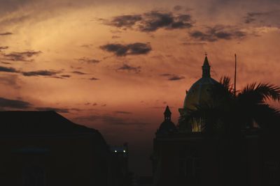 Low angle view of silhouette building against sky during sunset