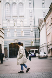 Man walking on footpath in city