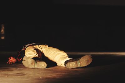 Low section of man lying on road at night