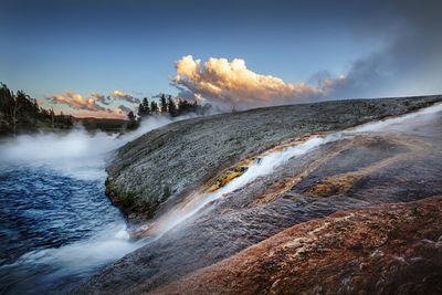 Scenic view of waterfall against sky