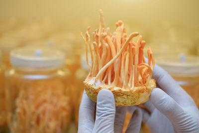 Midsection of person holding ice cream in jar