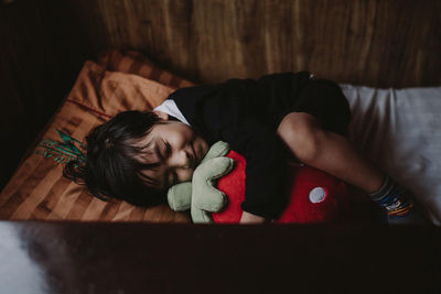 High angle view of boy sleeping on bed