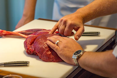 Cropped hands of man making meat at commercial kitchen