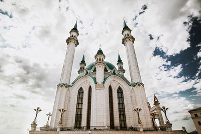 Low angle view of mosque against cloudy sky
