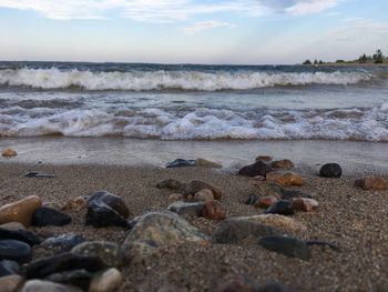 Close-up of pebbles on beach against sky