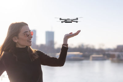 Small drone landing on young woman's palm