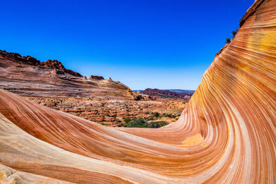 Scenic view of desert against clear blue sky