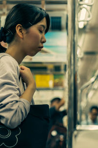 Side view of woman looking through train window