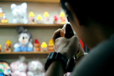 Close-up of man shooting toys with rifle in store