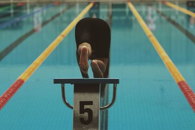 Rear view of swimmer jumping in pool