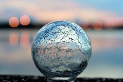 Close-up of crystal ball against sea