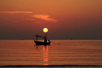 Silhouette boat in sea against sky during sunset