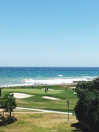 Scenic view of beach against clear blue sky