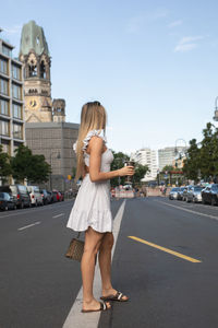 Side view of woman walking on road