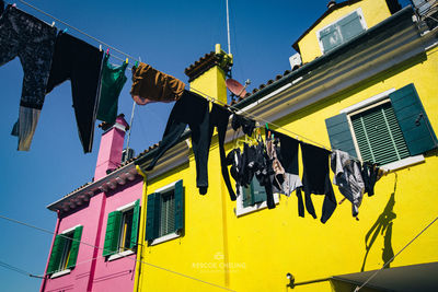 Low angle view of clothes drying outside building on sunny day