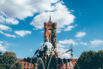 Low angle view of sculpture at fountain against rotes rathaus