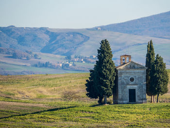 Built structure on field by mountains against sky