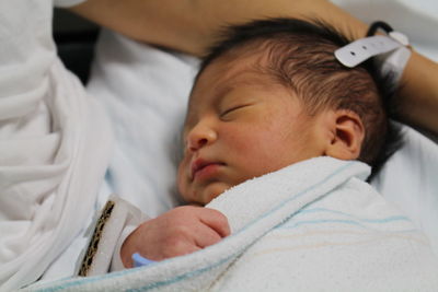 Close-up of baby sleeping in bed