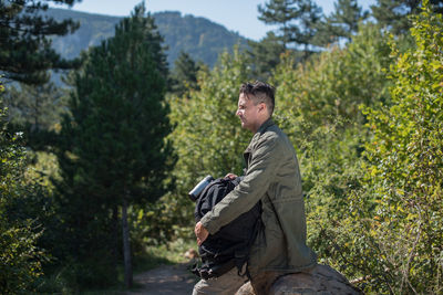 Side view of young man against plants