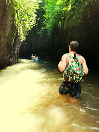 Rear view of people sitting on riverbank