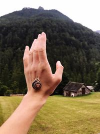 Cropped image of person hand on mountain