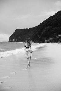 Rear view of woman walking on beach