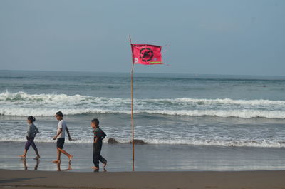 People on beach against sky