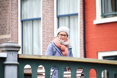 Low angle view of young woman standing against building on a bridge in netherlands