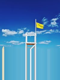 Low angle view of flag against blue sky